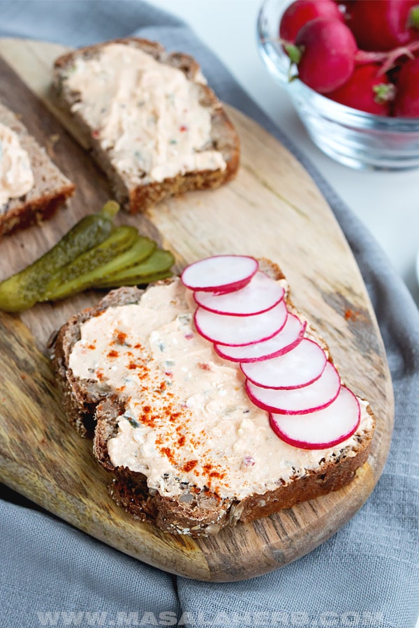 Liptauer cheese spread over whole wheat bread slice with pink radish slices and paprika