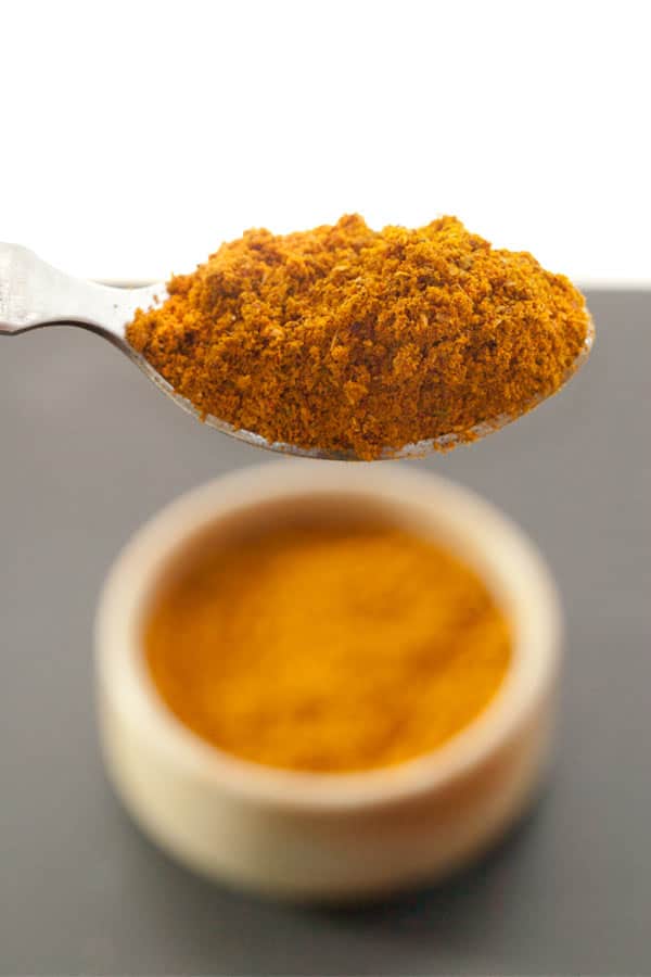 close up of yellow curry powder in spoon