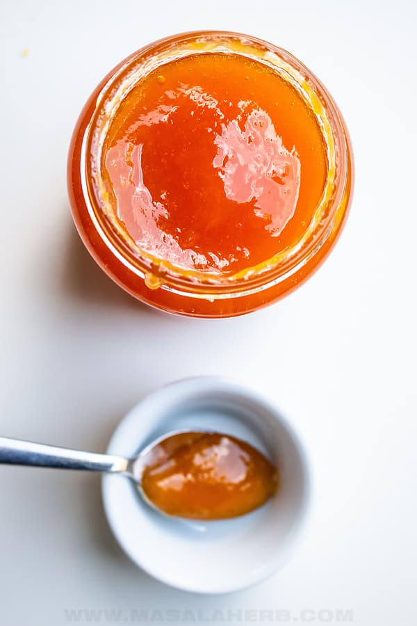 homemade peach jam in jar and in spoon