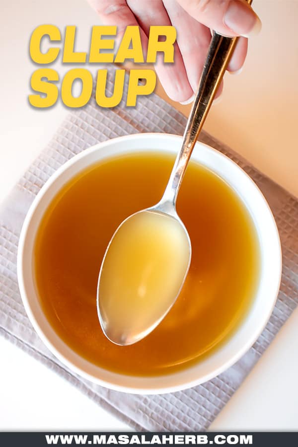 clear soup in a bowl and spoon