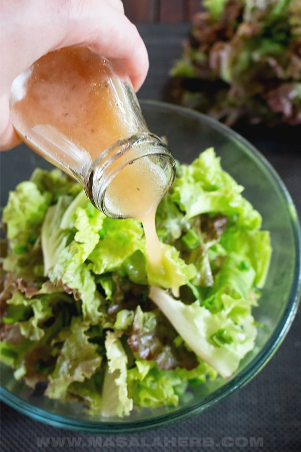 dressing poured over green lettuce salad