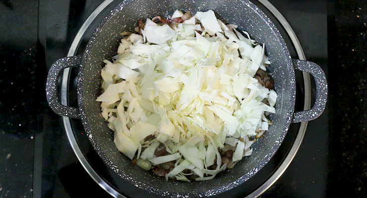 Season with black pepper, add in cabbage. Sauté cabbage until soft.