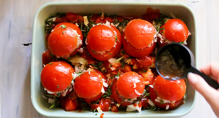 add tomato sauce and seasoning to the baking dish with stuffed tomatoes