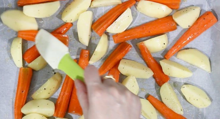 spread potatoes and carrots over sheet pan