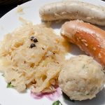 Sauerkraut bread dumpling and sausages on a plate