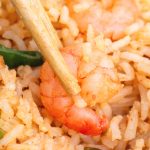 close up of shrimp fried rice with chopsticks