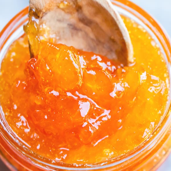 fruit preserve with kumquat in a spoon and jar