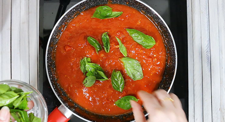 cook down sauce and flavor with fresh basil leaves