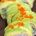 bright green dragon roll close up with tobico orange fish roe as topping