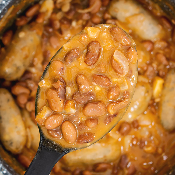 creamy pinto beans with sausages inn a pan