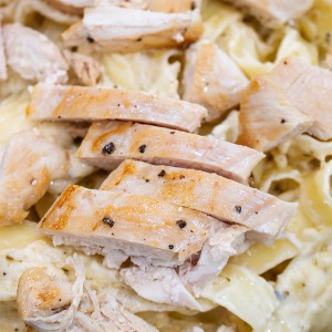 cut chicken breats over alfredo pasta
