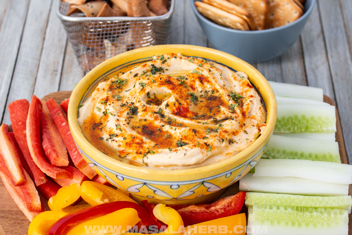 side view of dipping hummus in a bowl