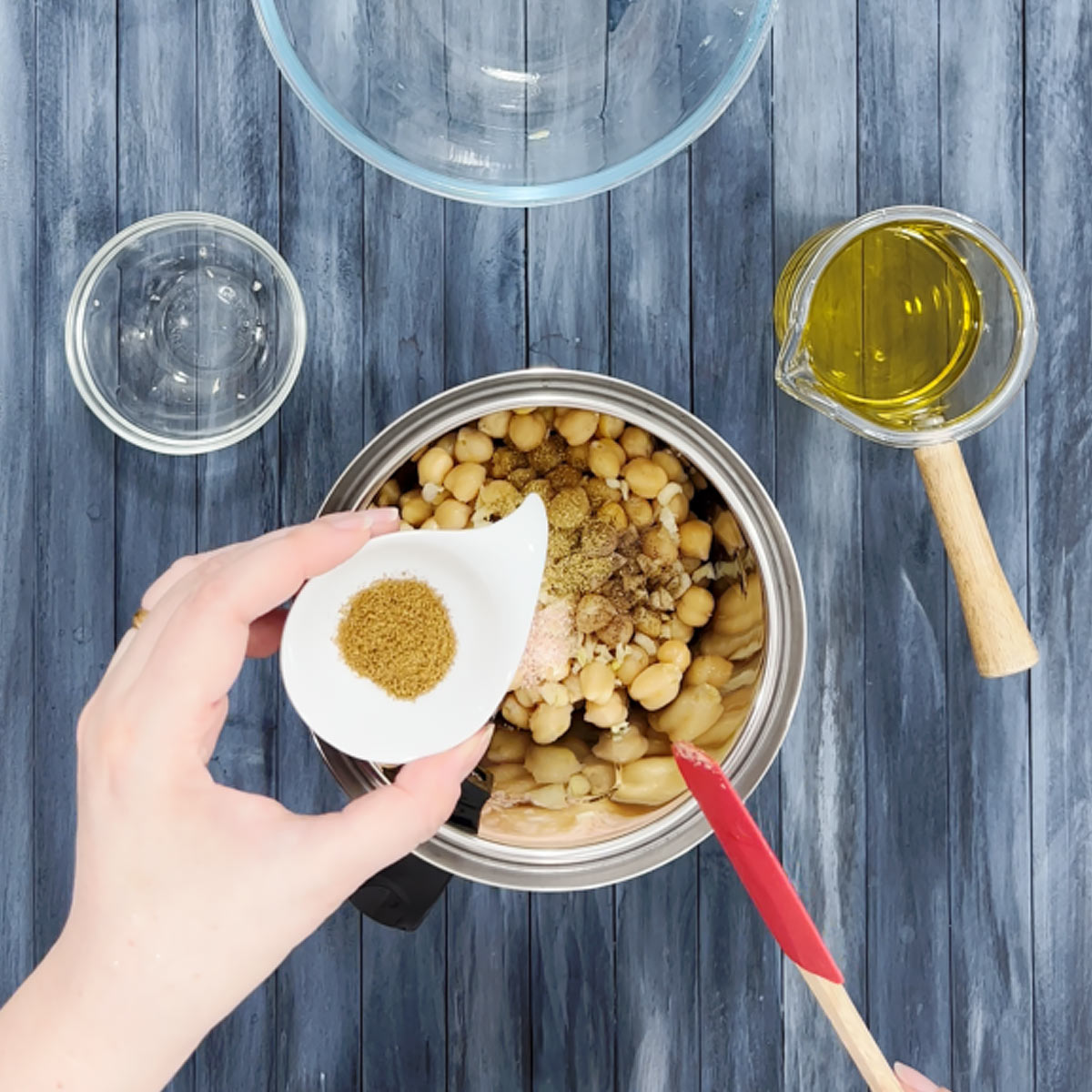 adding cumin to chickpeas in blender jar