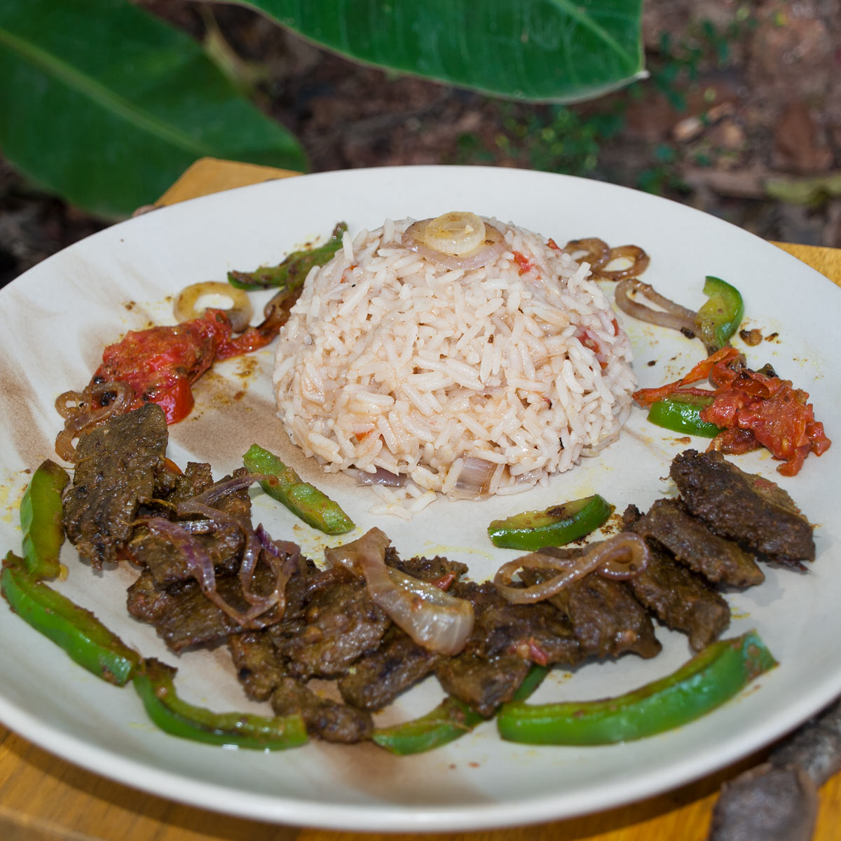 Beef Liver with green bell pepper slices fried and pulao rice on a plate