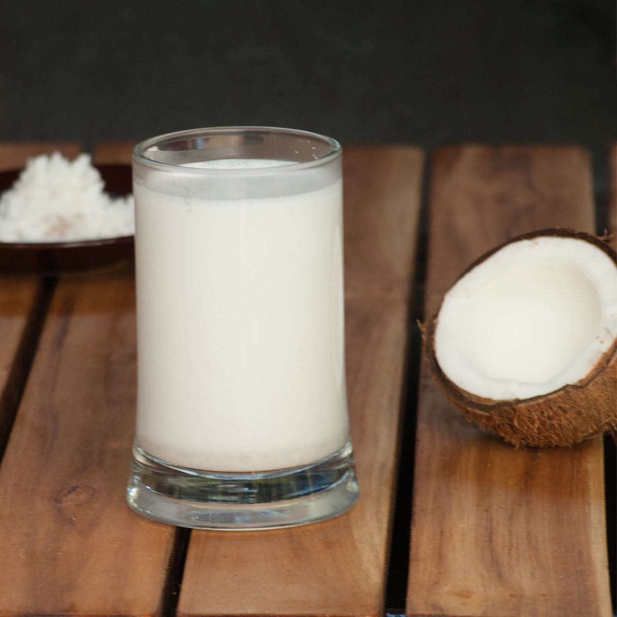 Homemade Coconut Milk in a glass with a cut open coconut