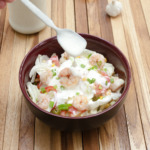 Lime Yogurt Dressing over a tomato shrimp ice berg salad in a bowl