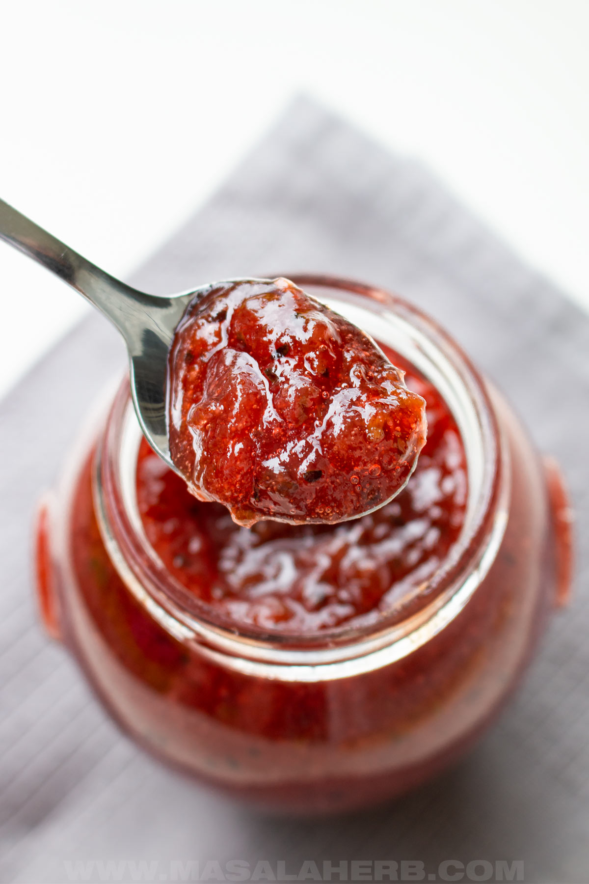 red gooseberry jam in a spoon