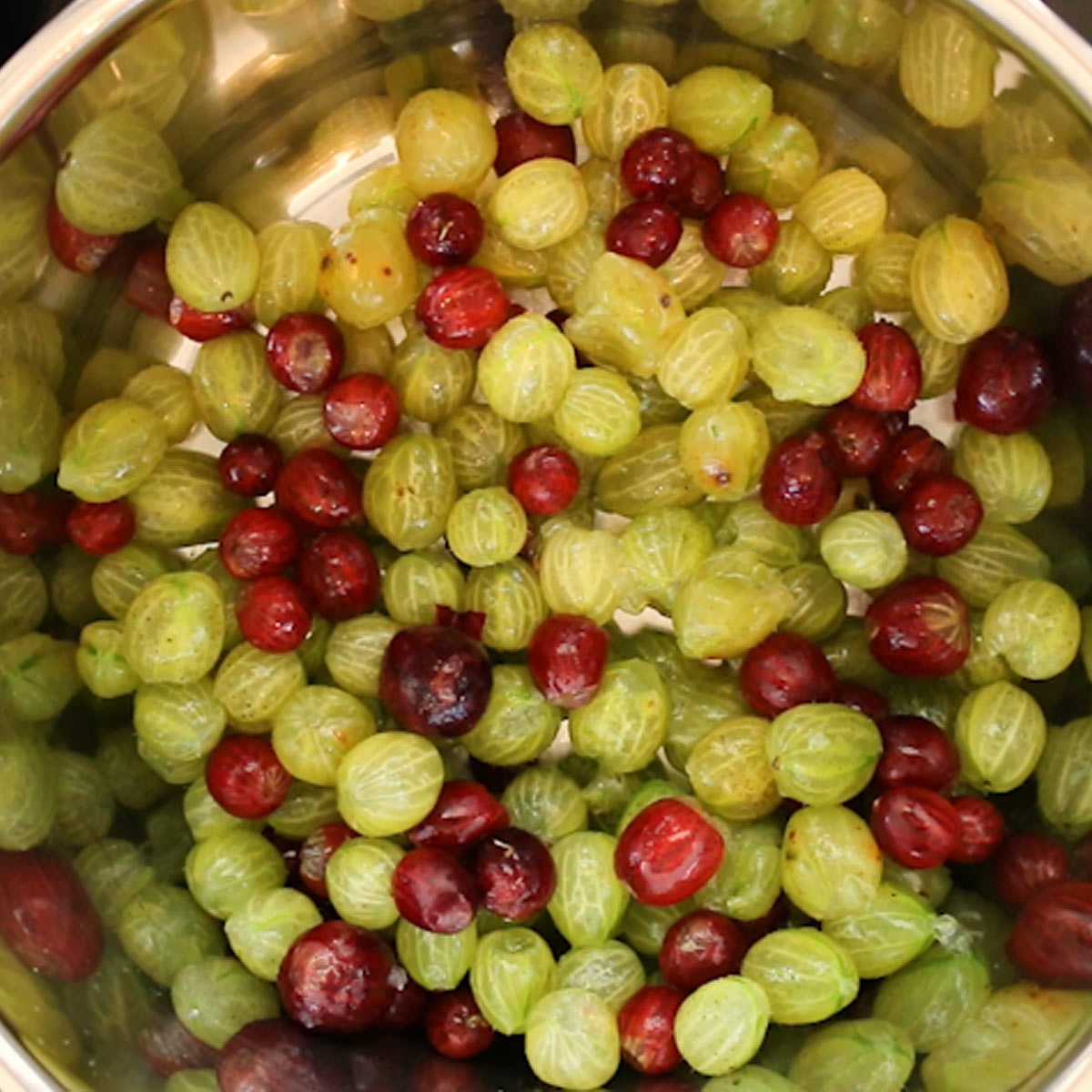 placing gooseberries into large pot