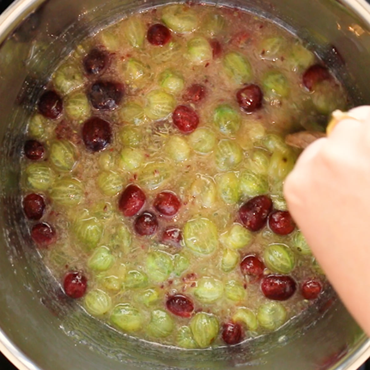 stirring sugar into gooseberries