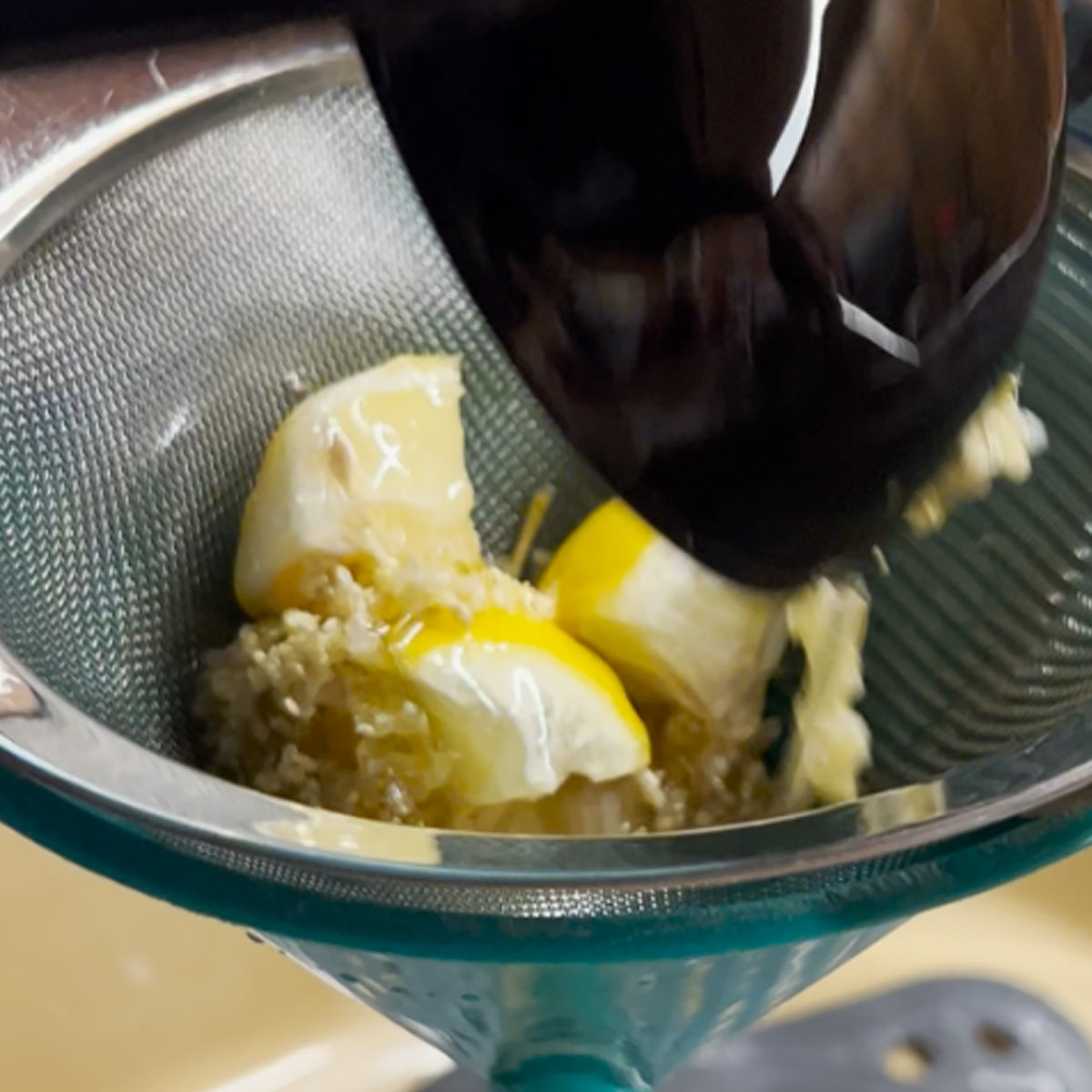 pour elderflower syrup into sieve and funnel