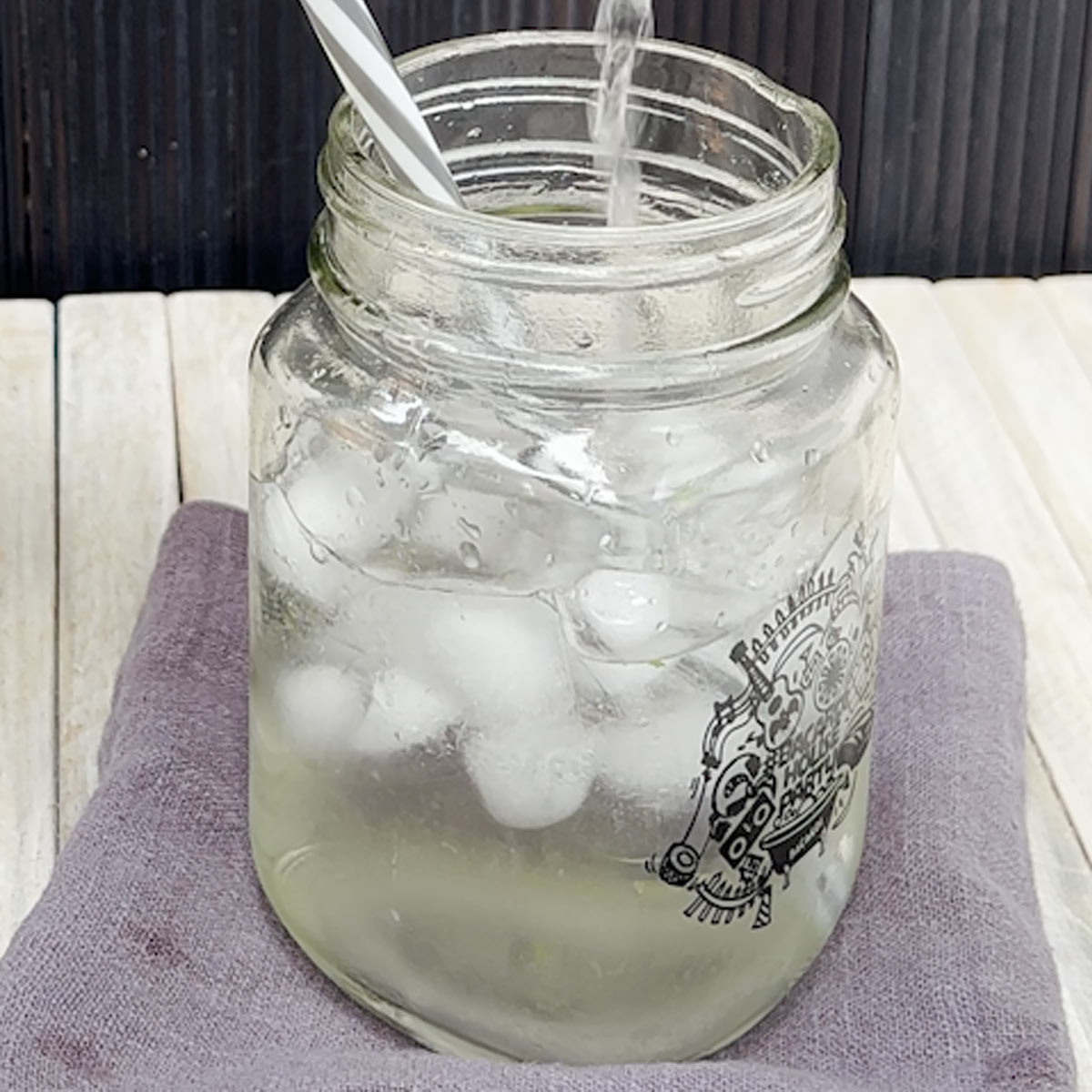 pour mint water into a glass with ice cubes