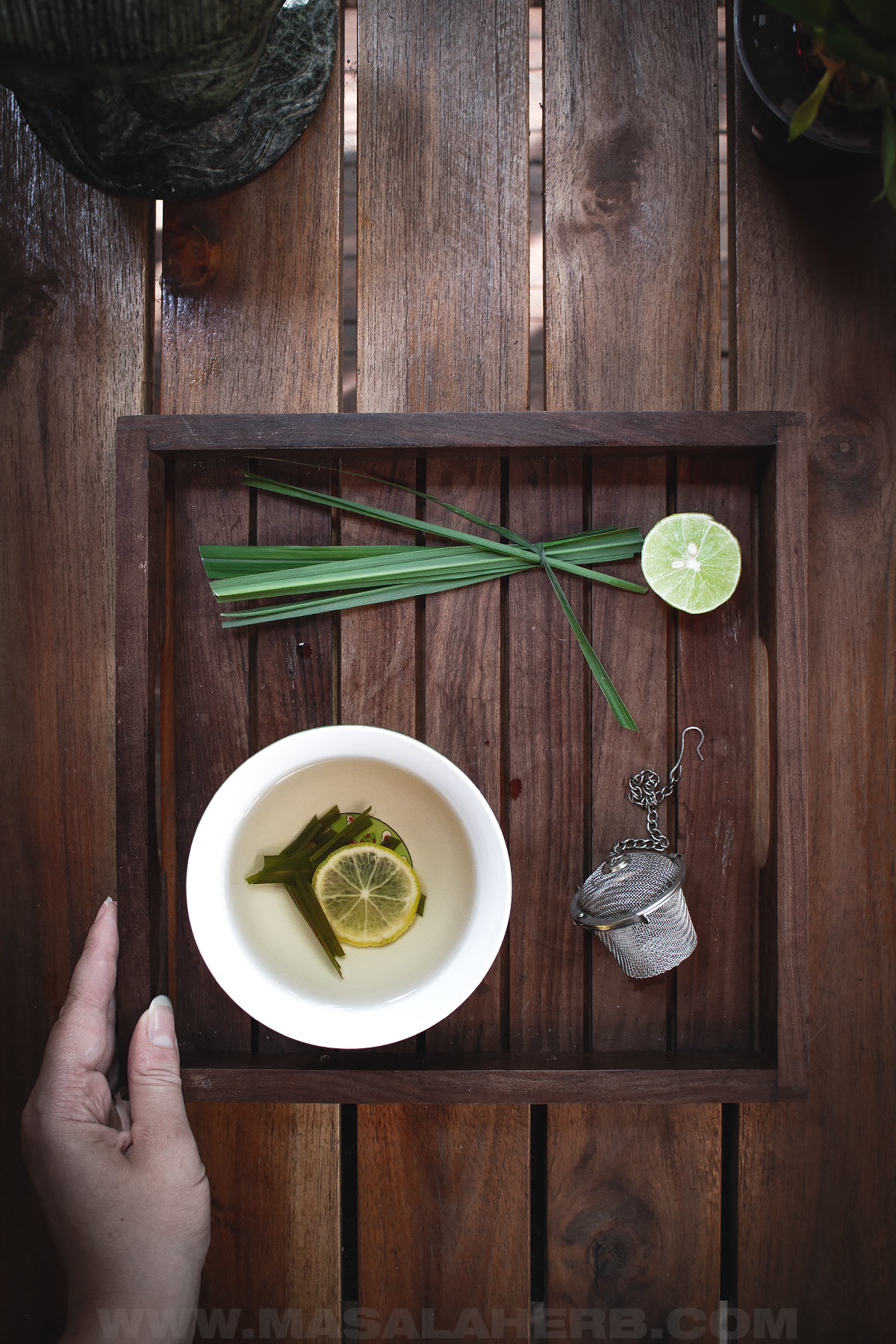 a tray of lemongrass with lemongrass tea and tea strainer top down view