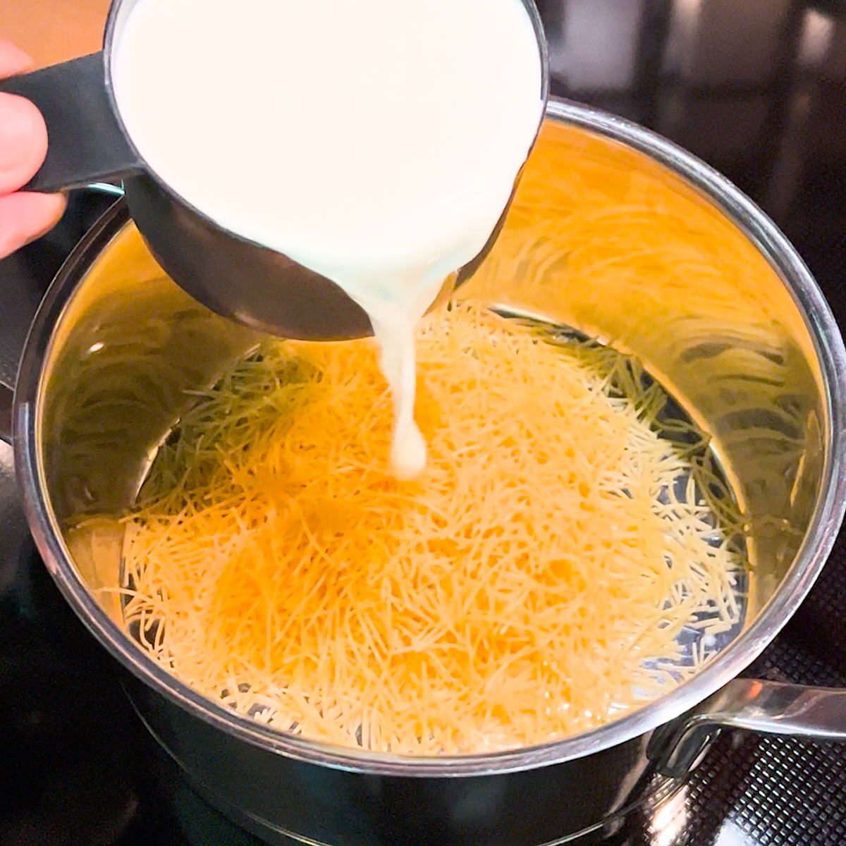 pour milk to vermicelli in a pan