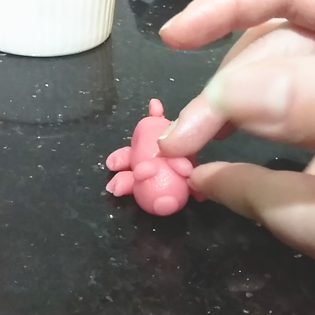 place ears and other body parts of marzipan pig