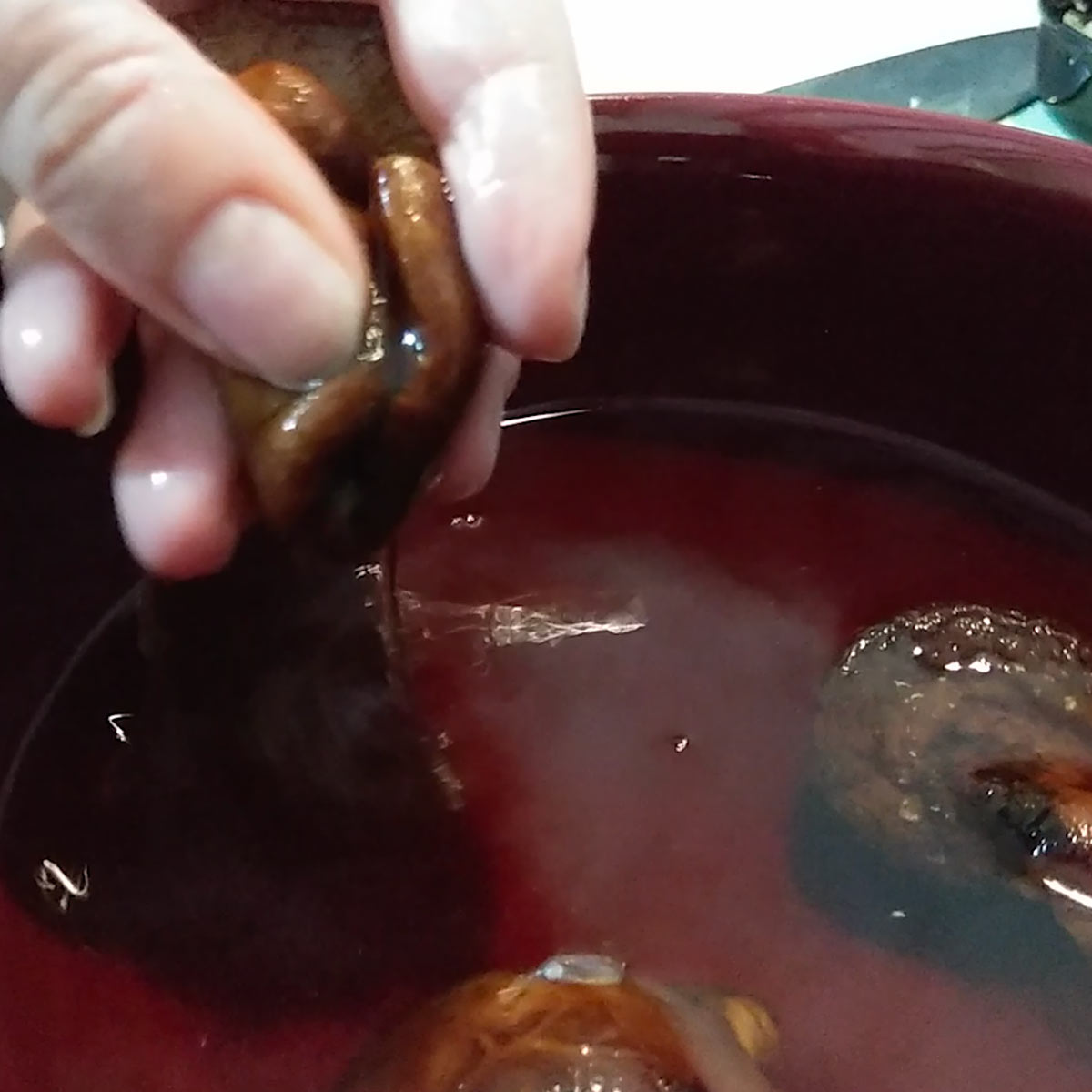 squeezing out water from the shiitake mushrooms