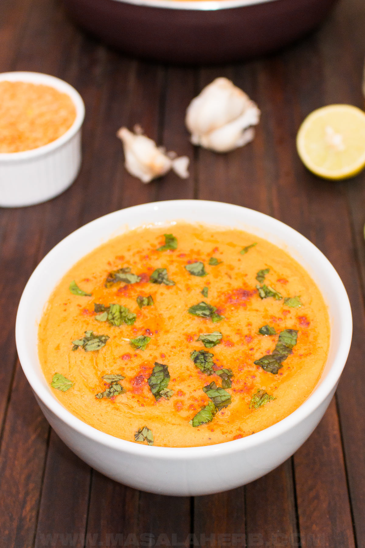 bowl of red lentil soup with topping