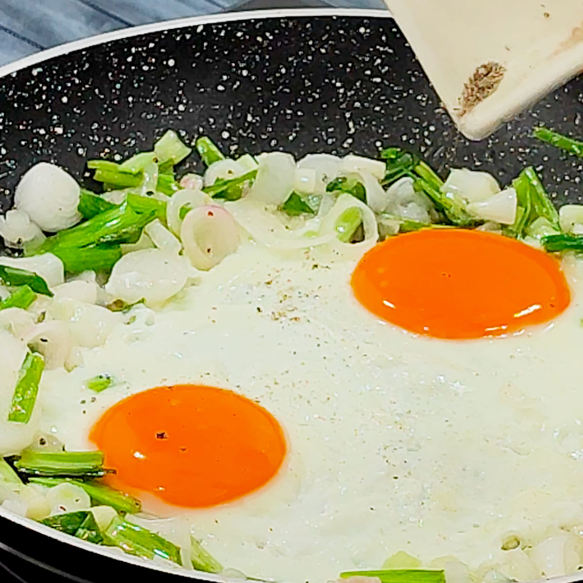 season eggs in the pan with pepper