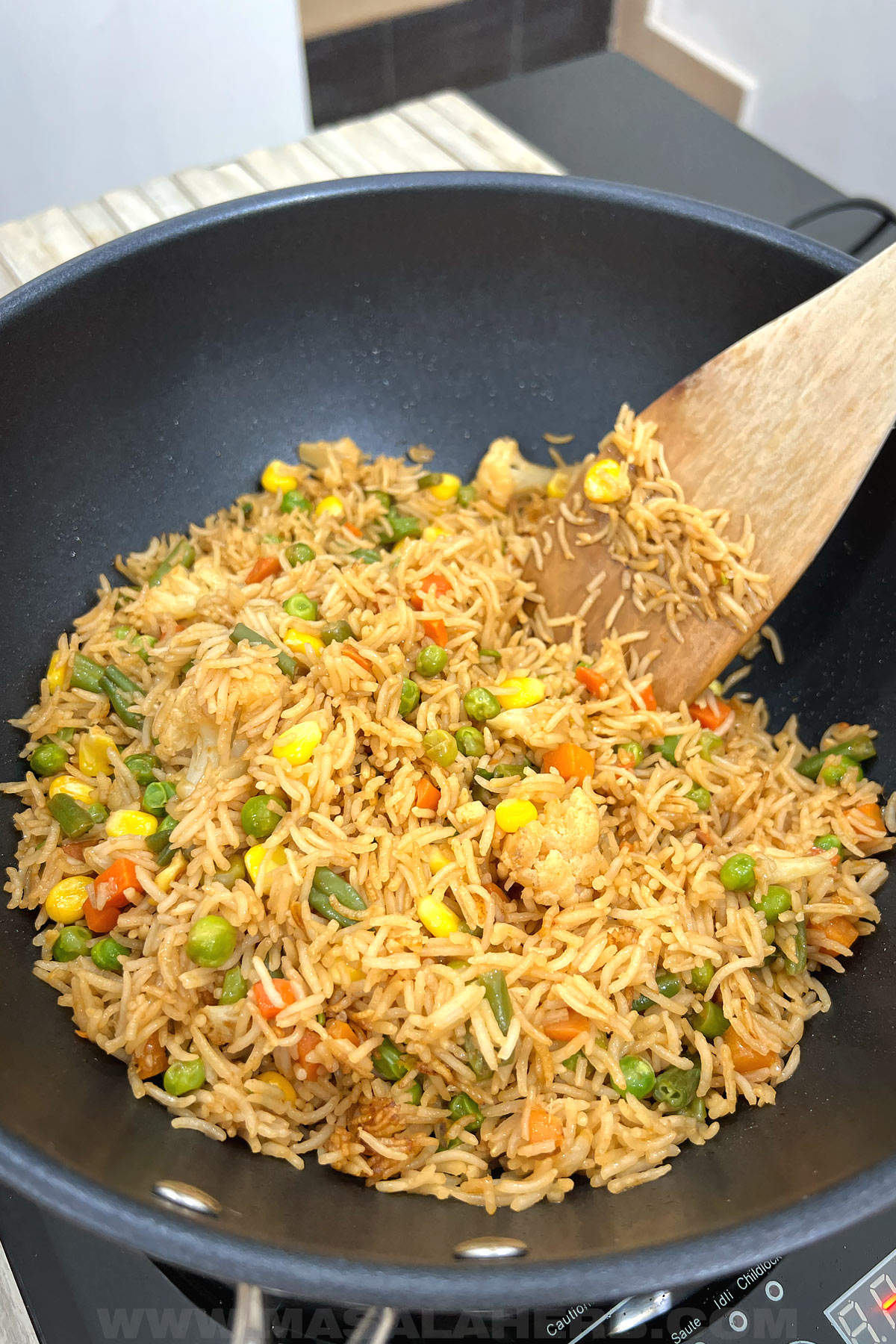fried rice in a wok with frozen vegetables