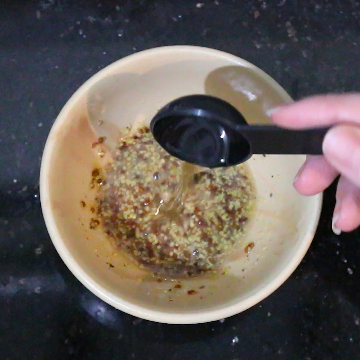 pouring oil to the other vinaigrette ingredients