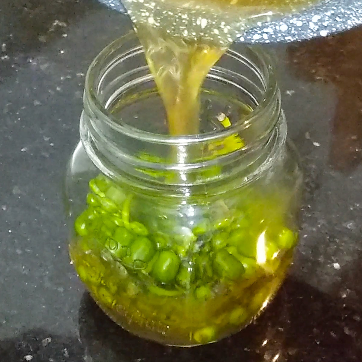 pour homemade brine over peppercorn in the jar