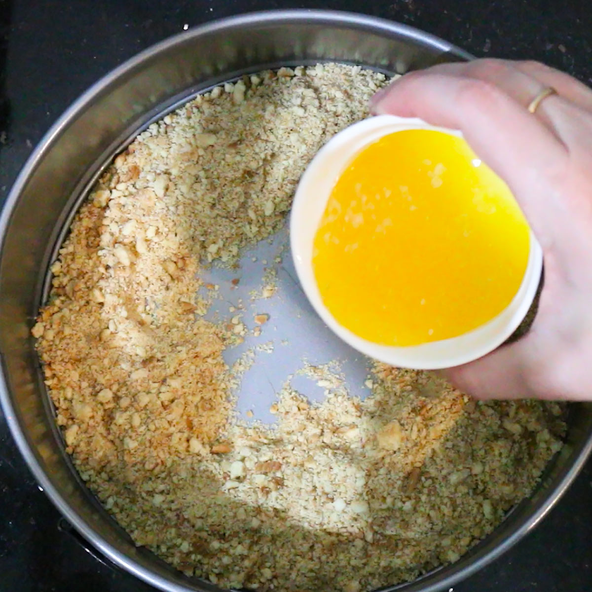 pour melted butter into crumbled cookies