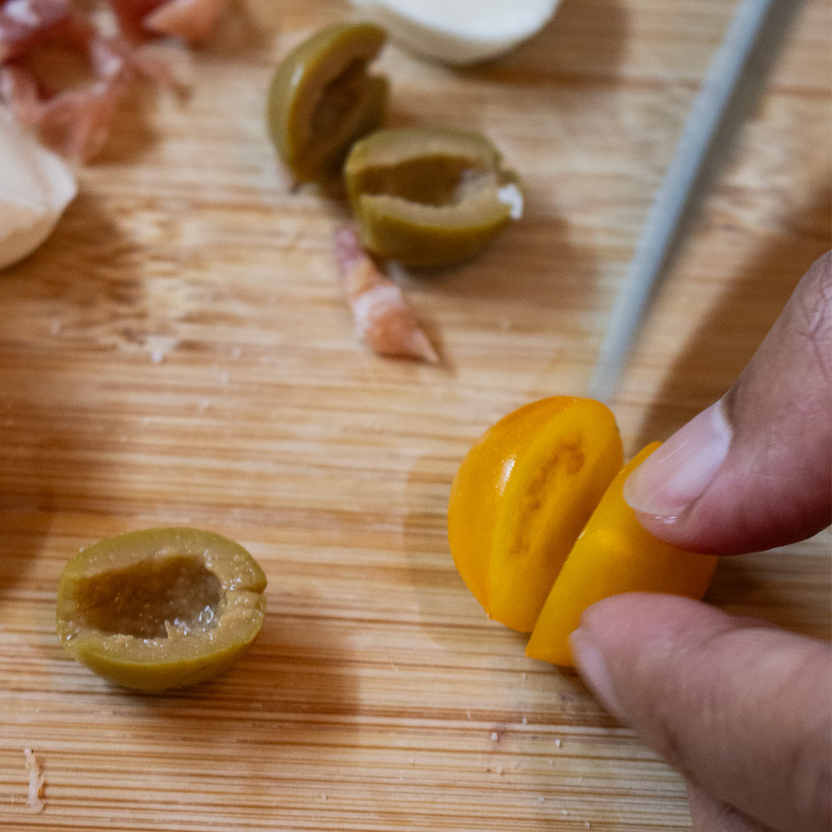 cut tomato and olives into two