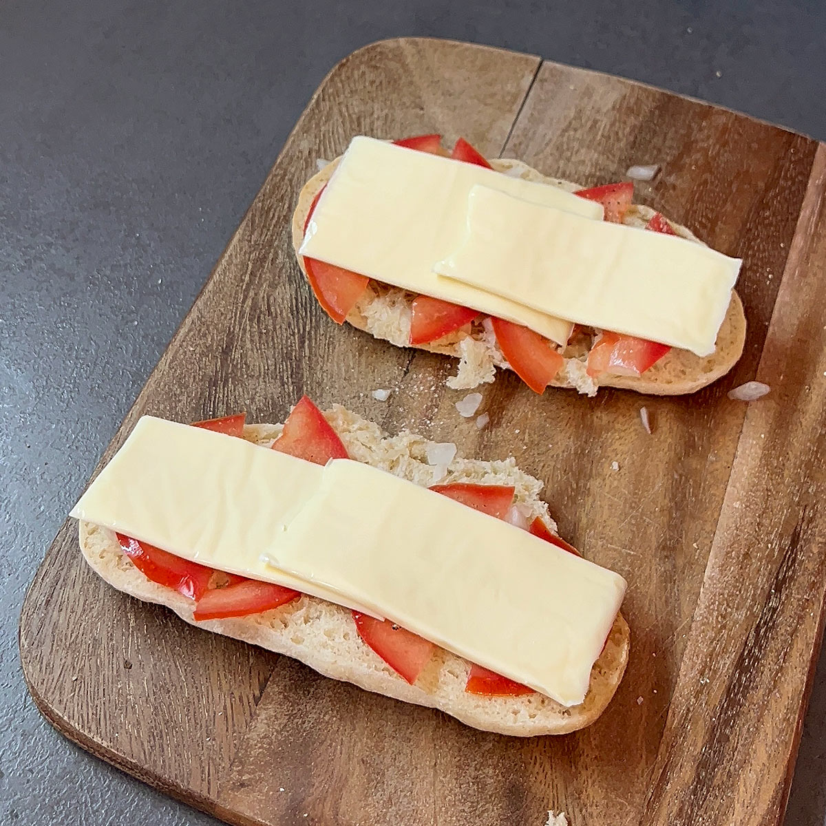 cut cheese slice in half and arrange over your tomatoes