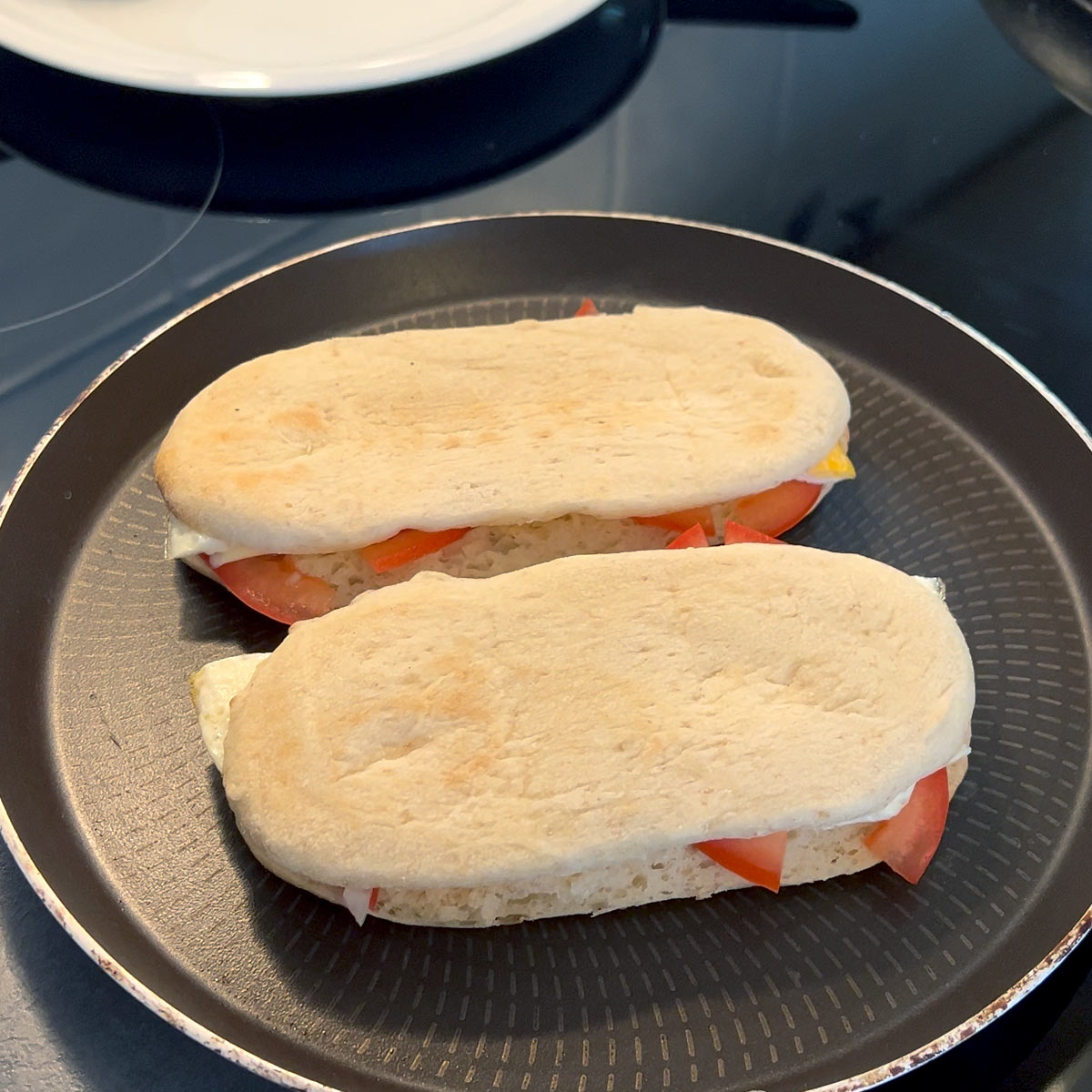 take panini through the panini press or use two pans to press down over the heat of a stove top
