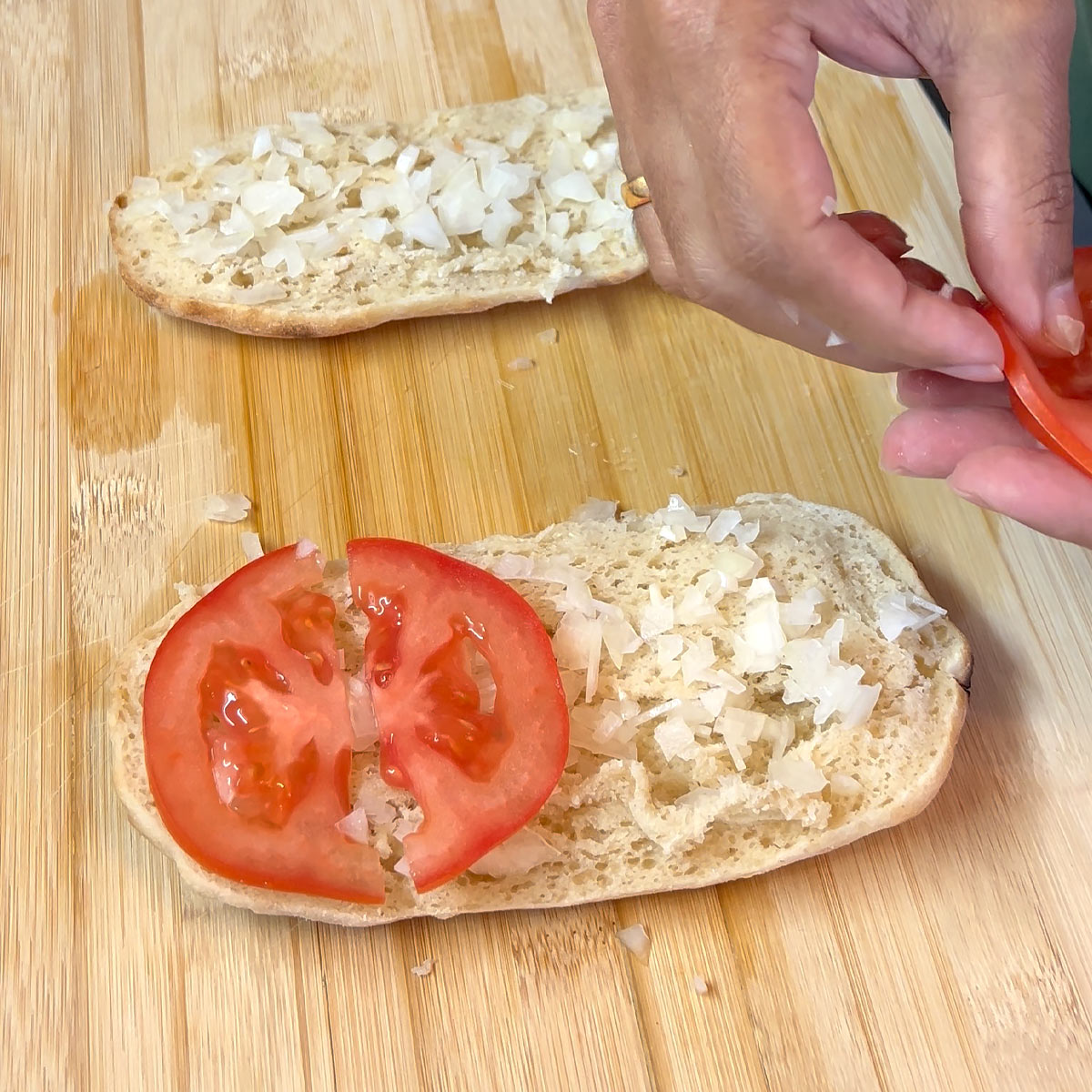 place sliced tomatoes and diced onions on panini bread