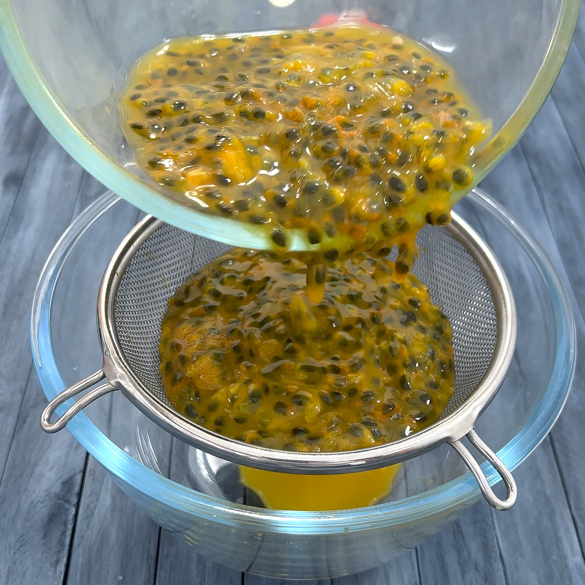 pour passion fruit pulp into a fine mesh strainer