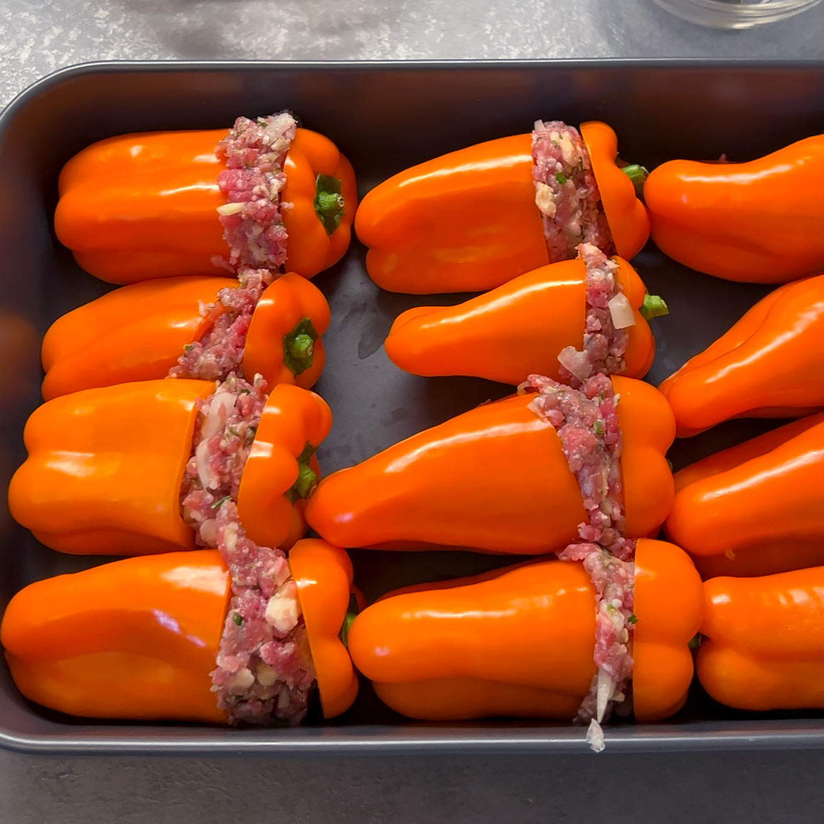 place meat stuffed peppers next to each other in the baking dish