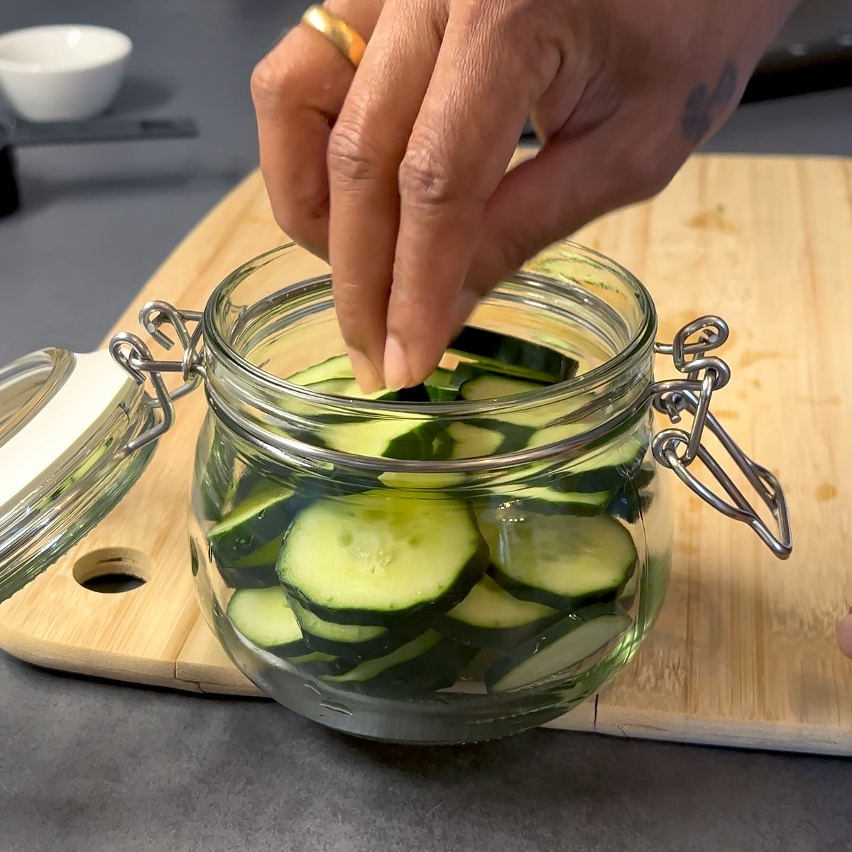 place cucumber into jar