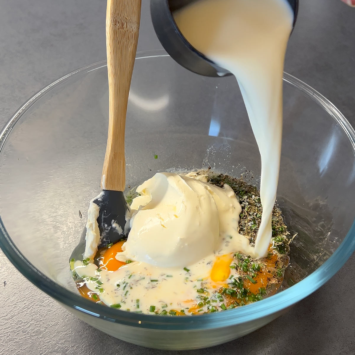egg, herbs, cream and milk in a bowl