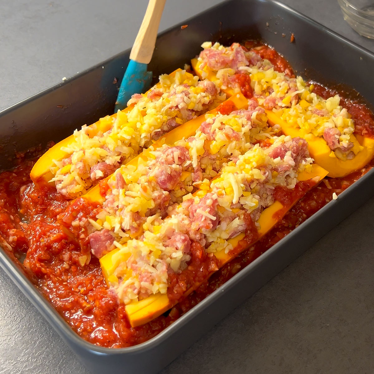 pour tomato sauce around zucchini