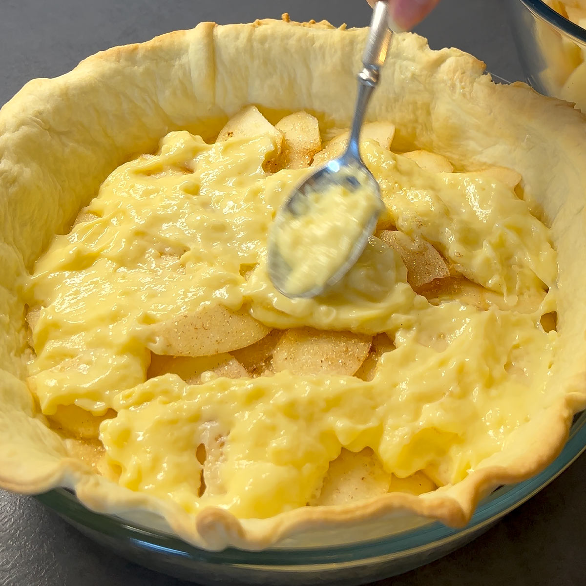 Spread half of the vanilla custard pie filling over the apples