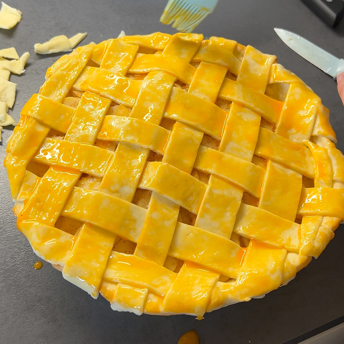 spread egg yolk over the top with a pastry brush