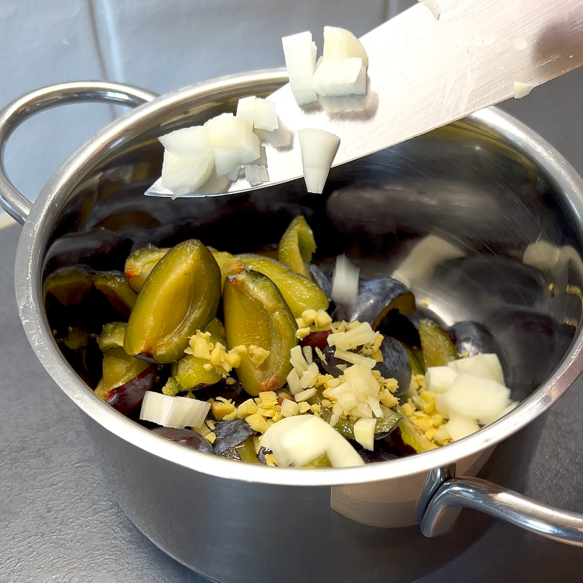 add plums, onion, ginger and garlic into a pan