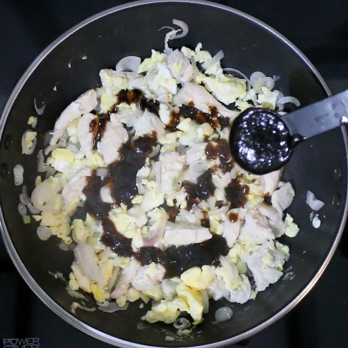 pour pad thai sauce over ingredient dish